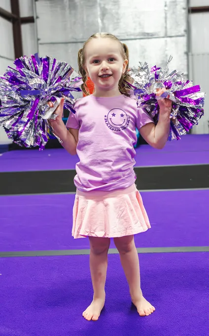 Youth cheerleading team performing synchronized routine with pom-poms