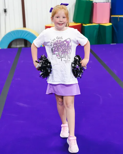 Energetic cheerleaders executing perfect synchronized routine with pom-poms and smiles