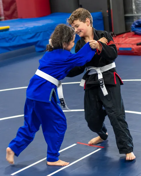 Young martial artists practicing wrestling technique with focused determination