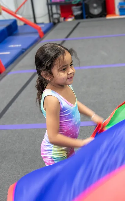 Toddlers enjoying safe gymnastics activities with colorful equipment