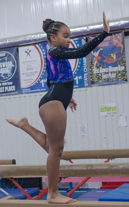 Young female gymnast performing competitive floor routine